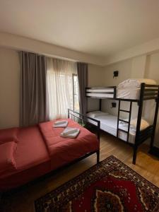 地拉那Vanilla Sky Boutique Hostel的一间卧室配有两张双层床和一张红色的床。