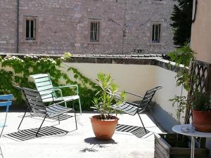 阿维尼翁英格兰酒店的庭院里摆放着几把椅子和植物