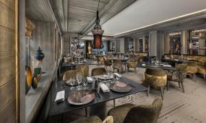 瓦勒迪泽尔Hotel Le K2 Chogori的一间带桌椅的餐厅和一间酒吧