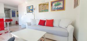 杜布罗夫尼克亚得里亚海明珠公寓的客厅配有带红色枕头的白色沙发