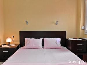尼亚普拉加Villa Vangelis的卧室配有一张大床和两个粉红色枕头