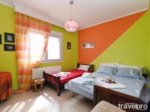 尼亚普拉加Villa Vangelis的一间卧室设有两张床,拥有橙色和绿色的墙壁