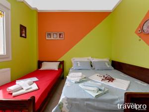 尼亚普拉加Villa Vangelis的绿橙色墙壁的客房内的两张床