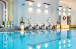 布加勒斯特奥赫第亚住宿及Spa的一个带白色椅子的游泳池和一个游泳池