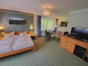 施塔特韦伦Pension Am Nationalpark的一间卧室配有一张大床和一台平面电视