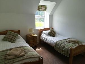 洛赫吉尔普黑德Keeper's Cottage的一间卧室设有两张单人床和一个窗户。