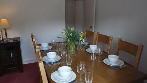 洛赫吉尔普黑德Keeper's Cottage的一张木桌,上面有盘子和玻璃杯