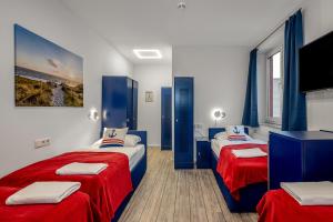 汉堡Koje Hostel的一间卧室配有两张红色和蓝色床单
