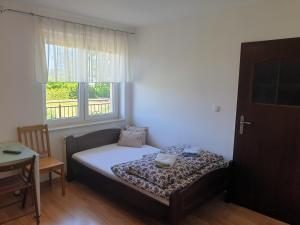波莫瑞地区卡缅POKOJE U MIKOŁAJA的一间小卧室,配有床和窗户