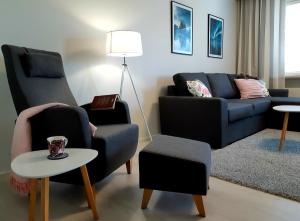 萨翁林纳Citykoti Kuutti的客厅配有两把椅子和一张沙发