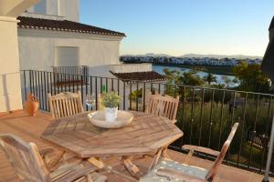 罗尔丹Casa Emperador - A Murcia Holiday Rentals Property的阳台上配有一张木桌和椅子,享有水景