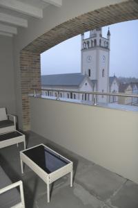 贝图夫Atmosfera Apartament 4的白色的建筑,阳台上设有钟楼