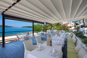 布德瓦亚历山大拉法鲁维奇酒店的一间设有白色桌椅的海洋餐厅