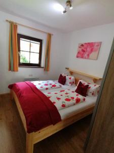 阿尔卑巴赫恭德布里克公寓的一间卧室配有一张带红色床单的大床和窗户。