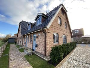韦斯特兰Haus Oscar in Westerland的黑色屋顶砖屋