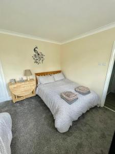 纽尼顿White Wings的一间卧室设有一张大床和一个木制床头柜。