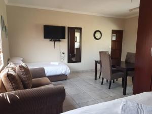 比勒陀利亚Private Apartments & Biz Stays Pretoria的酒店客房设有沙发、桌子和床。