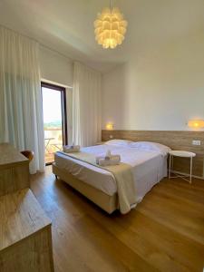 圣特奥多罗昂达玛莉娜酒店的一间卧室设有一张大床和一个大窗户