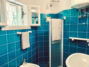 奥尔比亚Pinelopi Room的蓝色瓷砖浴室设有水槽和卫生间