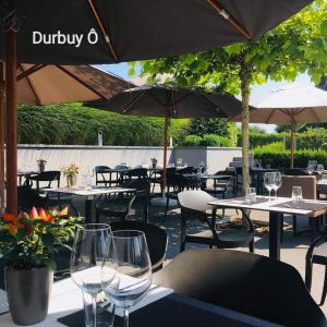 杜柏Durbuy Ô Restaurant Hotel Recharge Electric Car的一间带桌椅和遮阳伞的餐厅