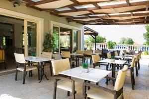 拉瑟Irilena Hotel的餐厅设有桌椅和窗户。