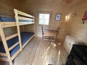 萨拉Karhunkierros Cabins & Huts的小屋内带双层床和书桌的客房