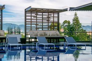 危地马拉危地马拉假日酒店的庭院内一个带椅子和沙发的游泳池