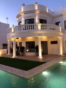 科尔多瓦La Quinta Hacienda的一座大型白色房子,前面设有一个游泳池