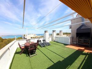 萨洛Barbacoa + vistas al mar + playa + piscina.的阳台的天井配有桌椅