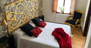 伊诺赫多诺利亚之家宾馆的卧室配有带红色枕头的白色床