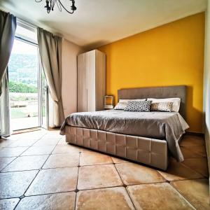 泰拉奇纳Il Sentiero di Leano的一间卧室设有一张大床和黄色的墙壁