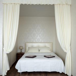 敖德萨Апартаменты в Одессе的卧室配有白色床和白色窗帘