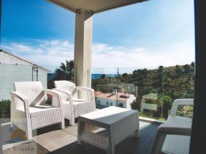 贝纳哈拉菲1minuto del mar ,vistas, Playa tranquila. Adaptado的阳台配有白色椅子和桌子,设有大窗户。