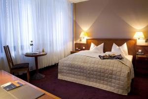 斯图加特罗斯酒店的一间酒店客房,配有一张带托盘的床