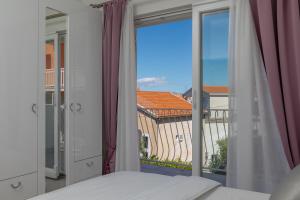马卡尔斯卡Hortenzija Apartments的一间卧室设有一张床和一个大窗户