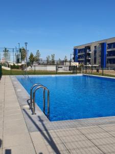 萨拉曼卡Apartamento nuevo, accesible y con piscina !!!的大楼前的蓝色海水游泳池