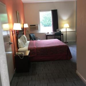 盖茨堡总统旅馆及套房酒店的配有一张床、一张书桌和一扇窗户的酒店客房