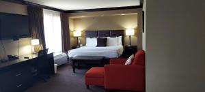曼哈顿帕克伍德套房酒店的酒店客房,配有一张床和一张红色椅子
