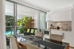 棕榈湾棕榈湾海滩公寓 的厨房以及带桌椅的用餐室。
