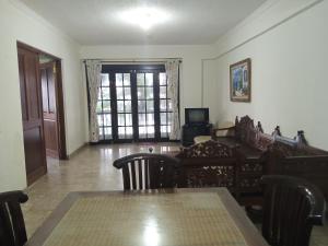 卡里塔KONDOMINIUM PANTAI CARITA - Neli的客厅配有桌椅和窗户。