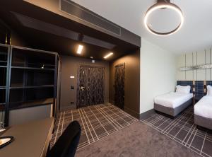 布雷斯特Бутик-отель Status的带两张床和一张书桌的房间和一间带一张床铺的房间