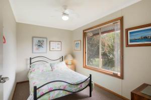 伊登莫纳洛别墅度假屋的一间卧室设有一张床和一个窗口