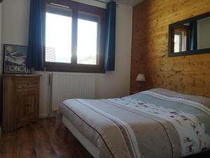 德沃吕伊La Souloise的一间卧室设有一张大床和一个窗户。