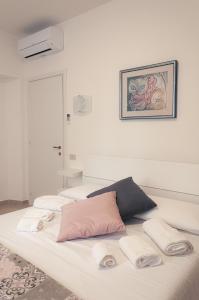 泰拉奇纳REPUBBLICA39 B&B的一张带白色床单和粉红色枕头的床