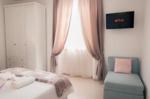 泰拉奇纳REPUBBLICA39 B&B的卧室配有床、椅子和窗户。