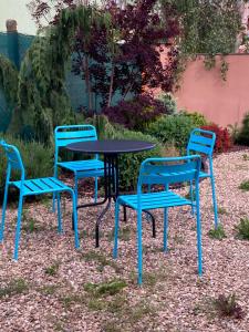 兹诺伊莫Apartmán Papoušek的三把椅子和一张桌子,一张桌子和一张蓝色的桌子和椅子