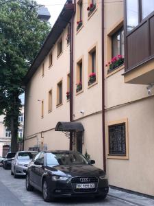 利沃夫B&B Apartment-Lviv的停在大楼前的一辆黑色汽车