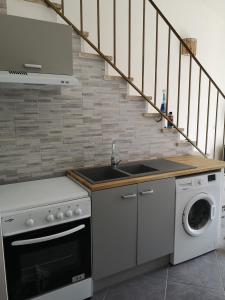 塞里尼昂Plénitude的厨房配有水槽和洗衣机
