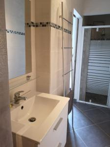 塞里尼昂Plénitude的浴室设有白色水槽和镜子