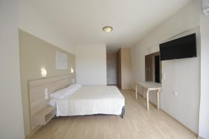 阿马林索斯Evia Riviera Resort的一间卧室配有一张床和一台平面电视